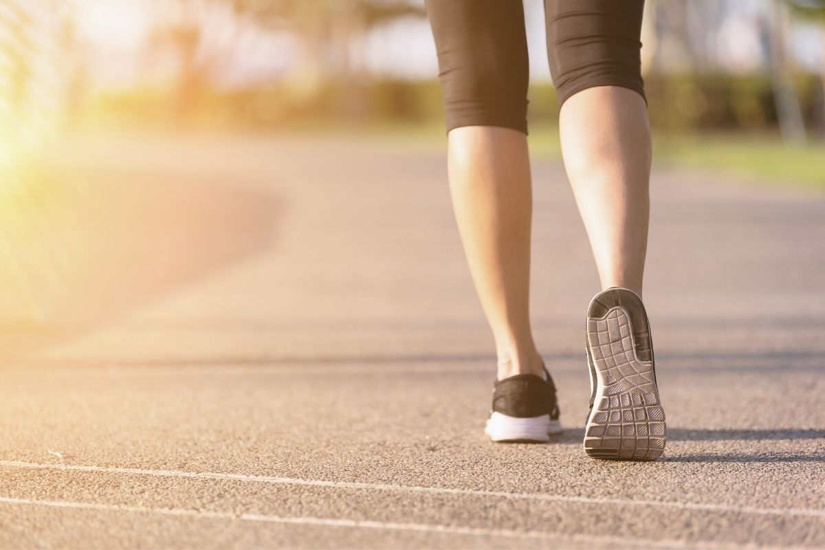 image of lower legs of a woman walking outdoors on a track on morning walk